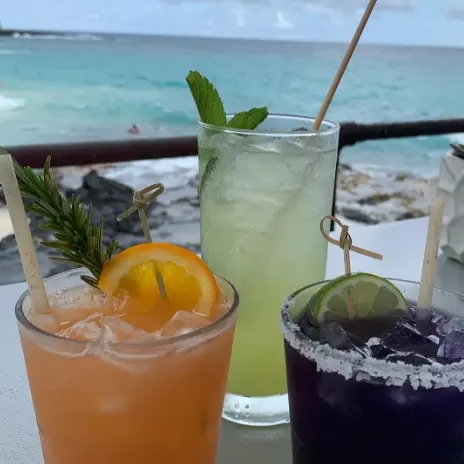 Three cocktails with a view of the ocean
